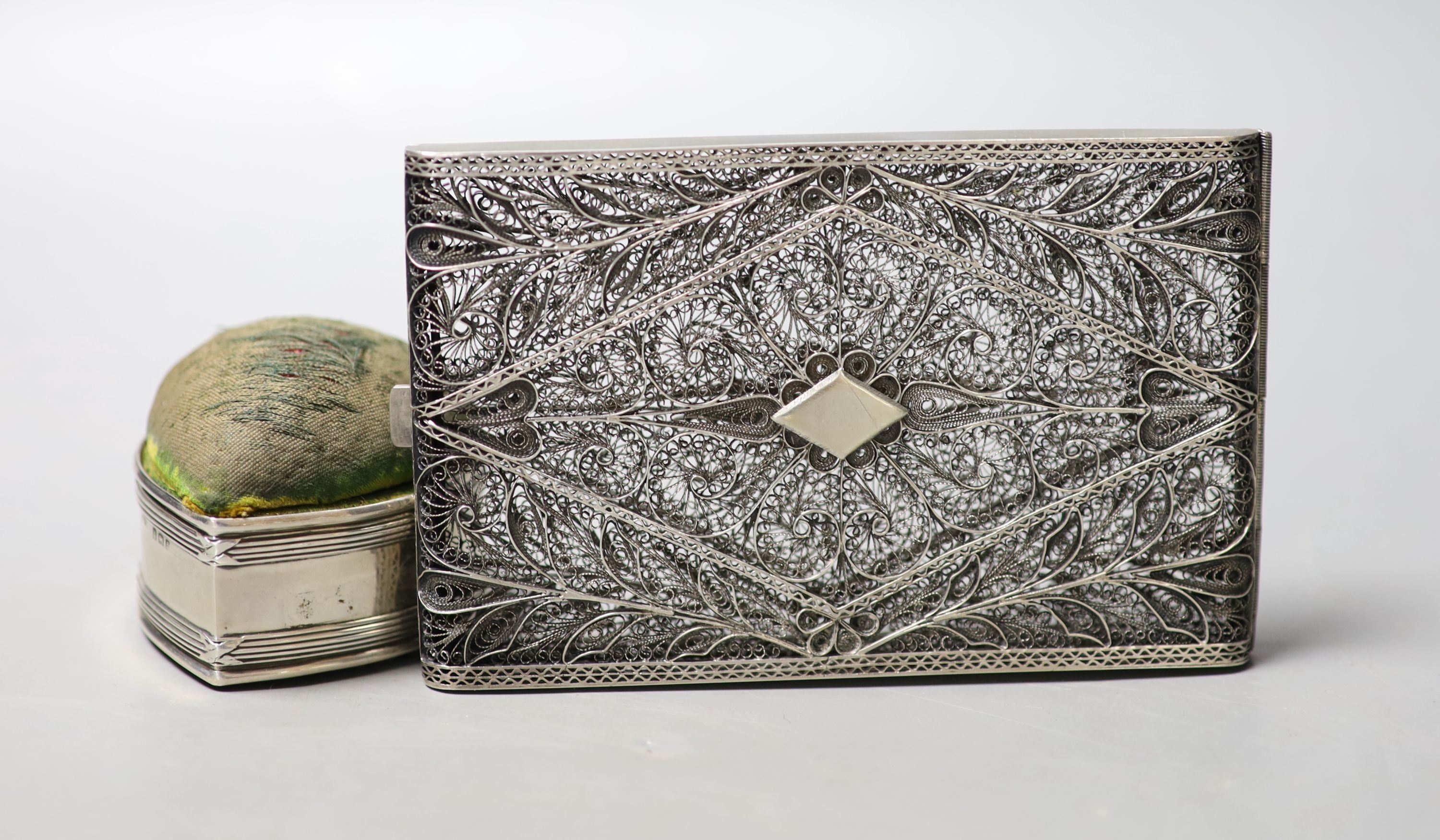 An Edwardian silver mounted heart shaped pin cushion, Birmingham, 1905, 52mm and a filigree white metal card case, 12.1cm.